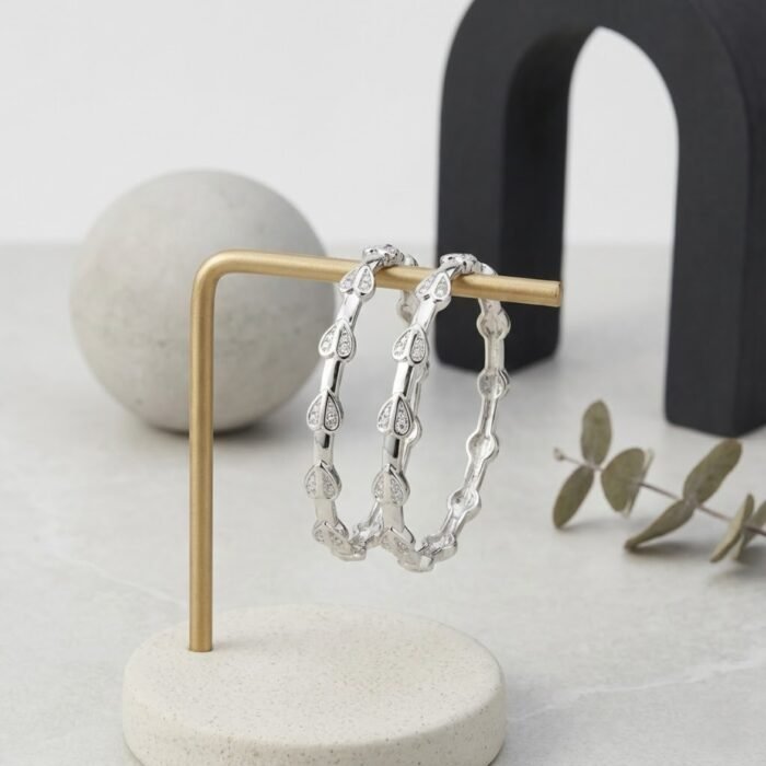 Luxury sterling silver bangles with micro detailing hanging on a modern stand – high-quality sterling bangles for daily wear and gifting