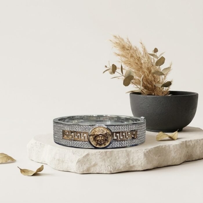 designer mens kada with gold centerpiece displayed on decorative props